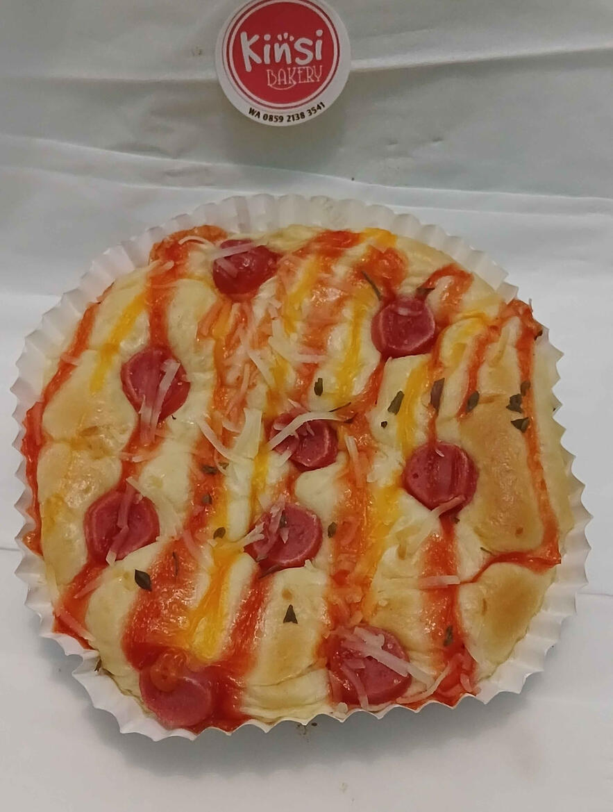 Sebuah roti bulat seperti pizza dengan topping sosis juga berbalur saus merah dan saus keju dan bertabur seperti seledri